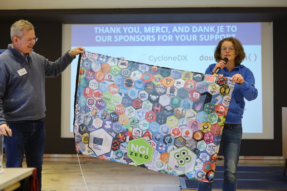 Tessel from NLNet pitching the funding programs and showing off the projects in a hex-sticker-flag.