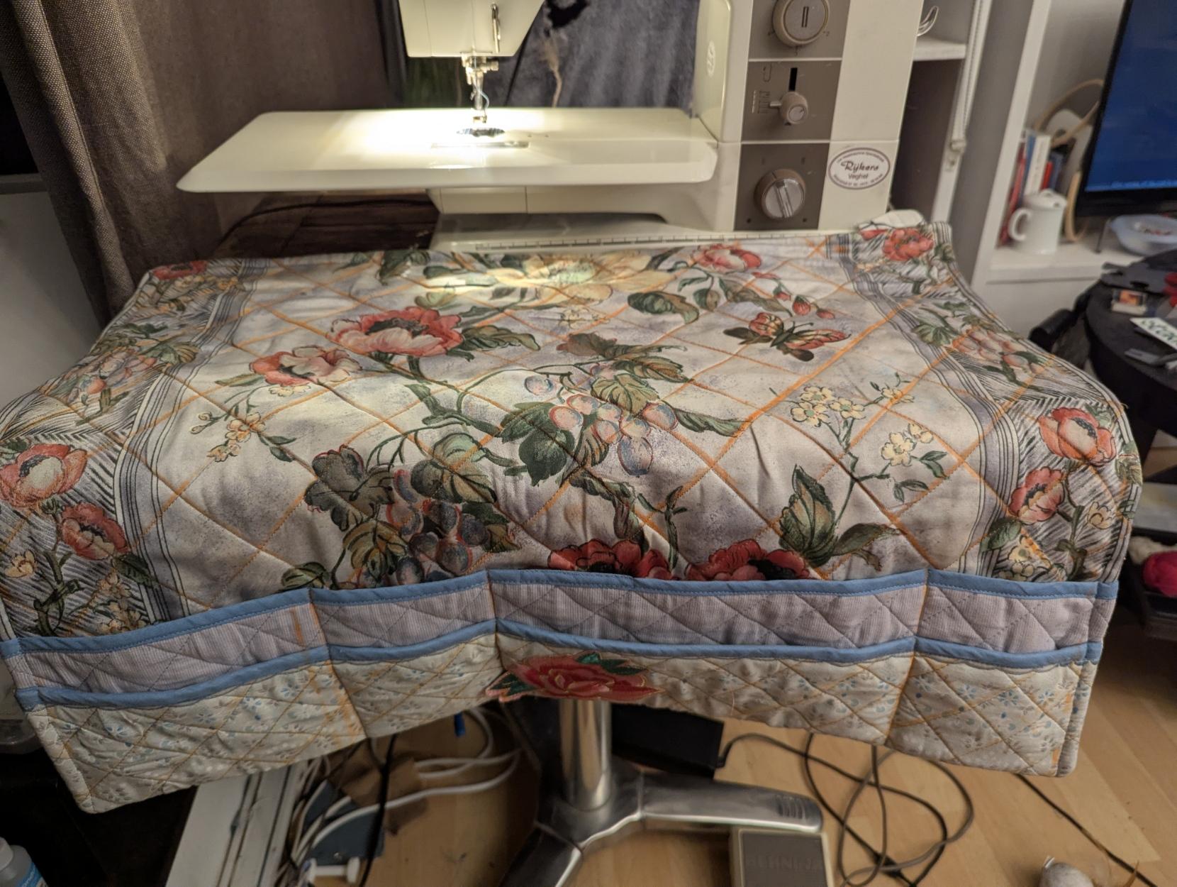 Another view of the sewing station, still without thread catchers. Orange chalk lines are visible along the quilted square pattern.