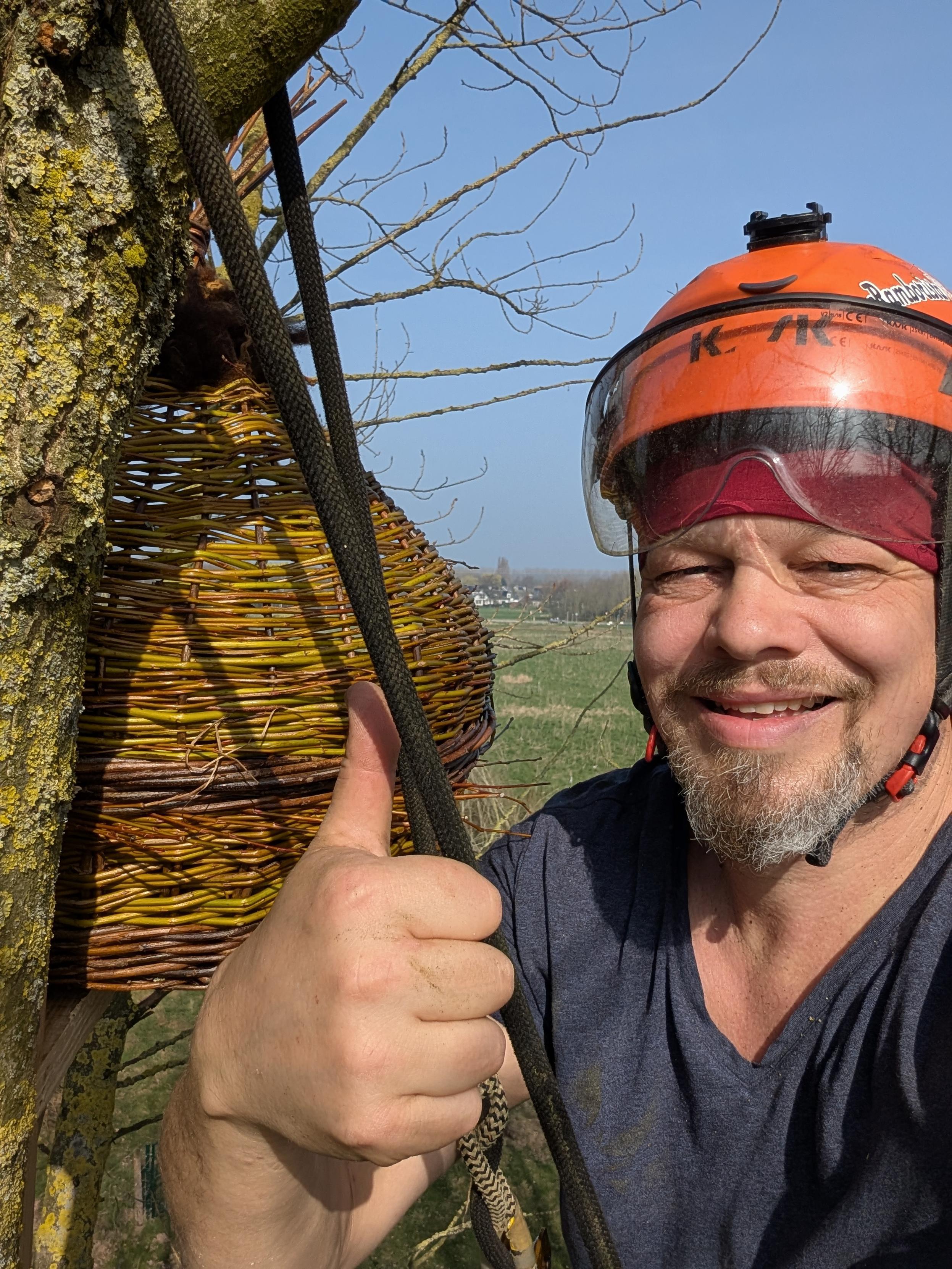 Een selfie van een klimmer nadat hij een uilennest in een boom in de tuin heeft opgehangen.